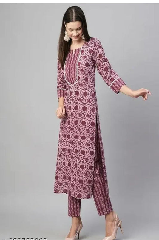 Woman wearing a patterned kurta with pants on a gray background