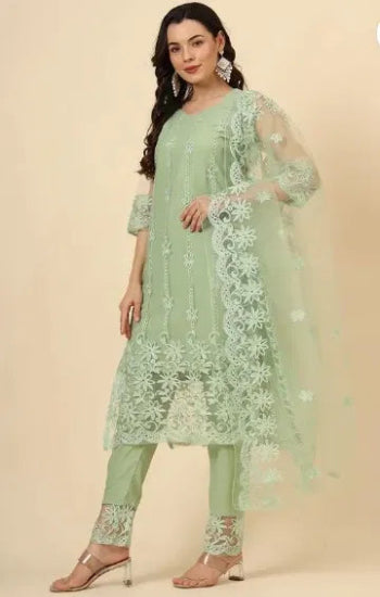 Woman wearing a light green embroidered outfit on a beige background