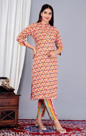Woman wearing a colorful patterned kurta with pants on a gray background