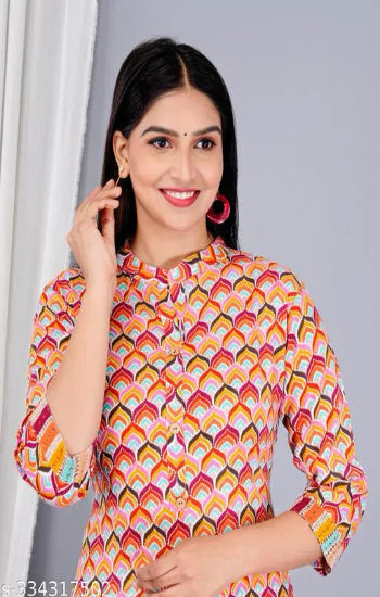 Woman wearing a colorful patterned top against a gray background